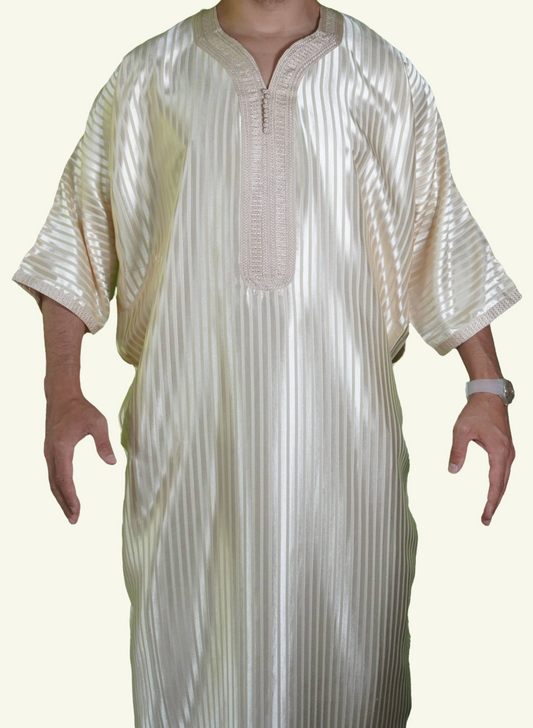 Ein männlicher Körper in einem gestreiften beigen Djellaba-Gebetskleid. Der Kopf und die Füße sind nicht sichtbar. Das Kleid zeichnet sich durch seine lockere und legere Passform aus.