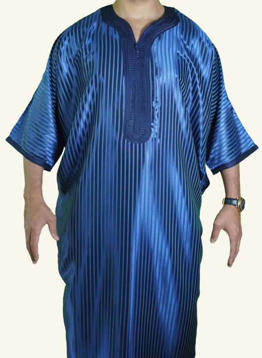 Ein männlicher Körper in einem gestreiften blauen Djellaba-Gebetskleid. Der Kopf und die Füße sind nicht sichtbar. Das Kleid zeichnet sich durch seine lockere und legere Passform aus.