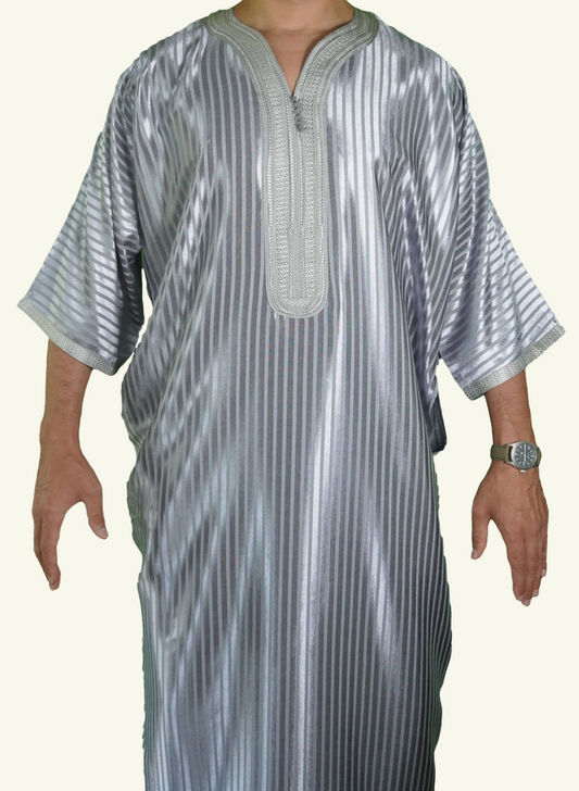 Ein männlicher Körper in einem gestreiften silbernen Djellaba-Gebetskleid. Der Kopf und die Füße sind nicht sichtbar. Das Kleid zeichnet sich durch seine lockere und legere Passform aus.