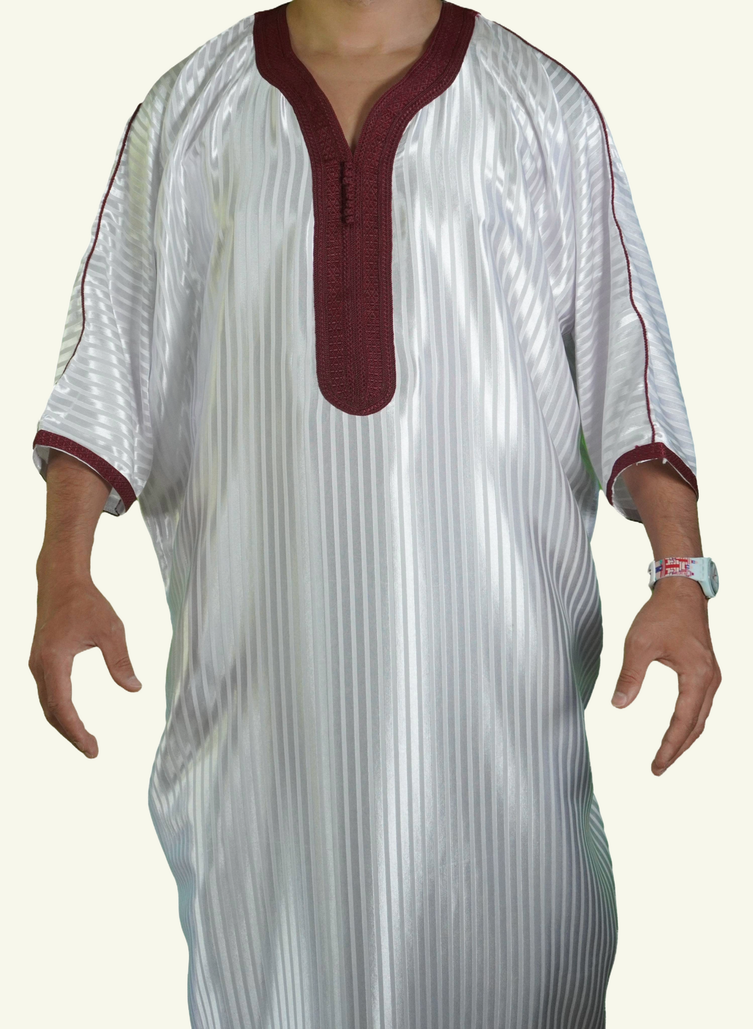 Ein männlicher Körper in einem gestreiften weiß-roten Djellaba-Gebetskleid. Der Kopf und die Füße sind nicht sichtbar. Das Kleid zeichnet sich durch seine lockere und legere Passform aus.