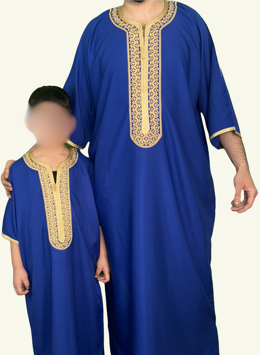 Ein stilvolles Bild, auf dem eine Djellaba Noble in Blau liegt, ein Symbol für Eleganz und Tradition. Das Strickmuster auf der Brust und die Enden der Ärmel sind mit goldenem Strick verziert, während ein Erwachsener und ein Kind im Partner-Look dieses Kleidungsstück tragen.